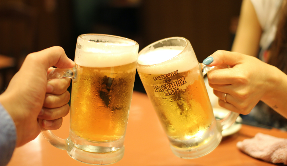 Zwei Freunde stoßen mit Bier an