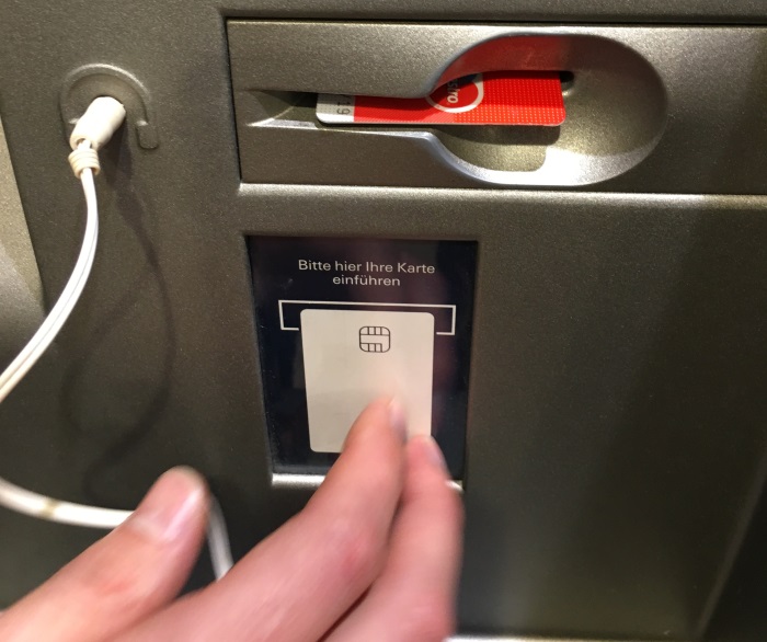 Geldautomat mit eindeutigem Kartenslot und den eingesteckten Kopfhörern