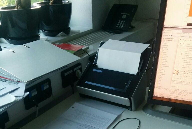 Mein Schreibtisch mit Dokumentenscanner. Wenig Arbeit alle zwei Wochen auf dem Weg zum papierlosen Büro.